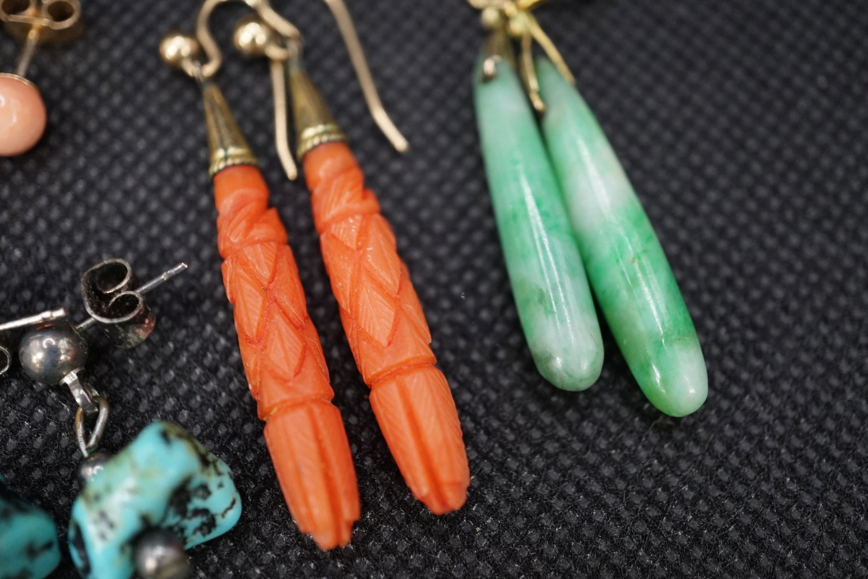 A pair of gilt metal and carved coral set teardrop shaped earrings, 38mm, a pair of similar shaped jade earrings and two other pairs of ear studs.